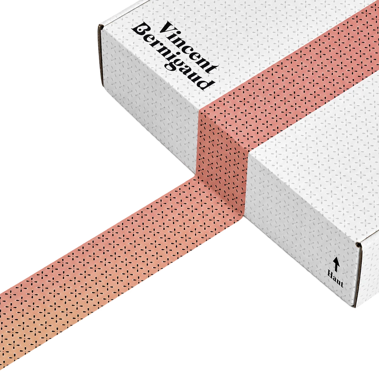 Boîte d’expédition blanche à motifs, ruban rose.